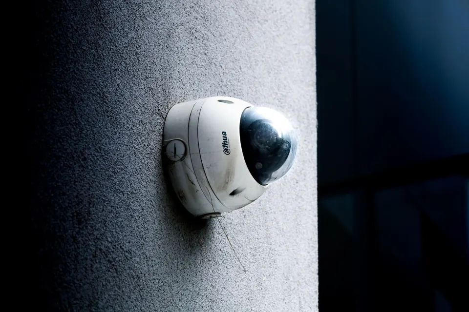 White dome CCTV camera on a textured exterior wall